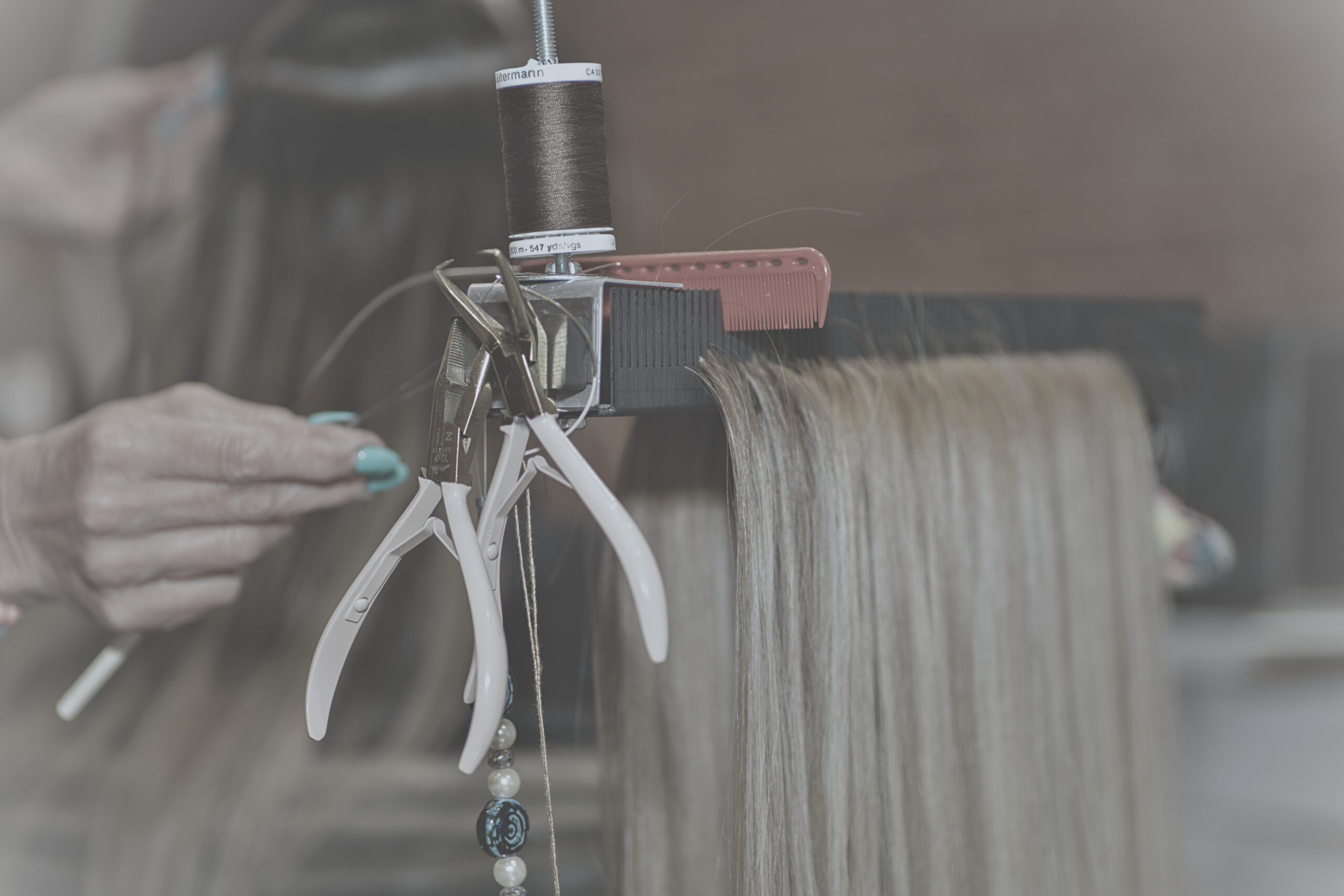 Hair Butler™ hair extension workstation tool has blondish hair and two special tools