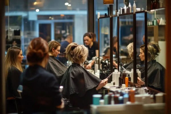 busy salon with clients and stylists with large mirrors Hair Butler™ hair extension workstation tool