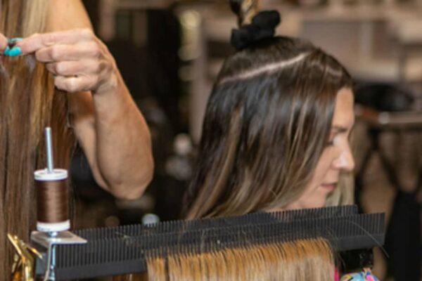 close up of professional hair stylist using Hair Butler™ hair extension workstation tool