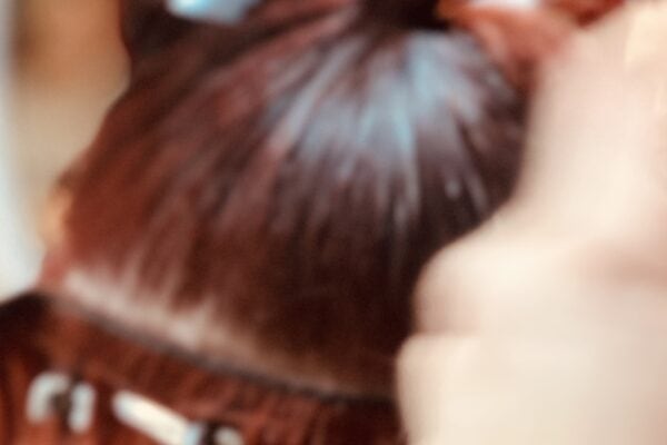 Stylist sectioning hair during a salon service, showing the preparation and setup needed behind the chair before the final look is created.