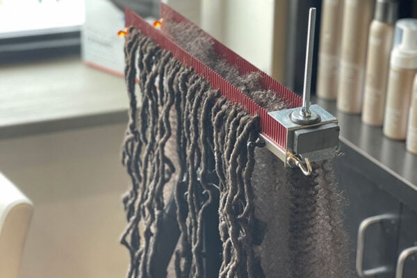 close up of dreadlocks ready for install in Hair Butler™ hair extension workstation tool