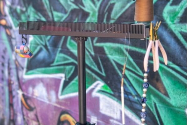 colorful wall behind Hair Butler™ hair extension workstation tool on a tripod