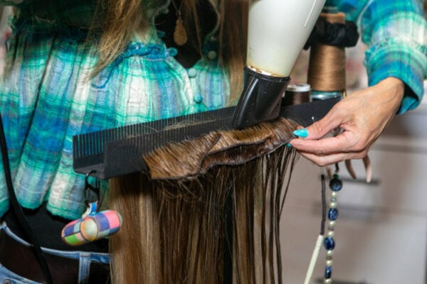 close up of extension hair being styled while on Hair Butler™ hair extension workstation tool