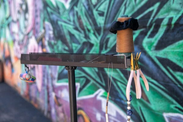 Hair Butler™ hair extension workstation tool ready to be used with colorful background behind the tool